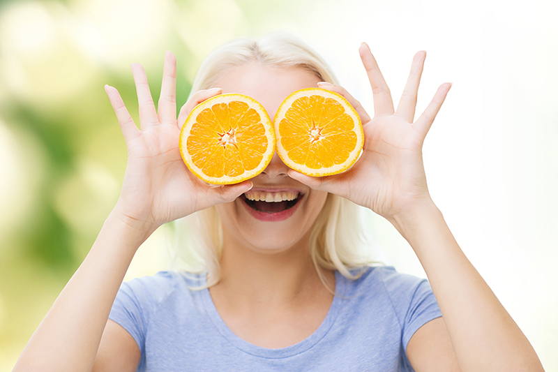 Woman holding orange slices, eye health