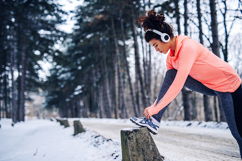 Woman working out during the winter time, staying motivated even though it's cold out