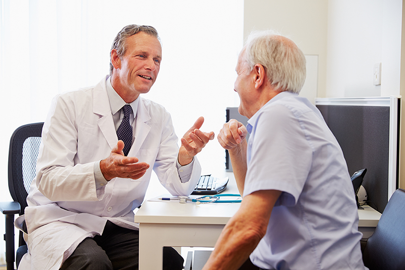 Medicare-aged man, visiting with a doctor at his annual wellness visit