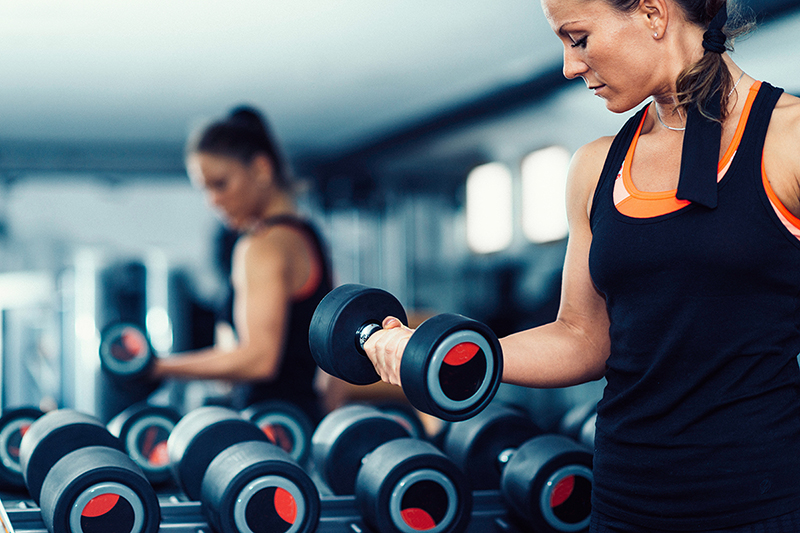 Woman lifting weights, which helps with heart health