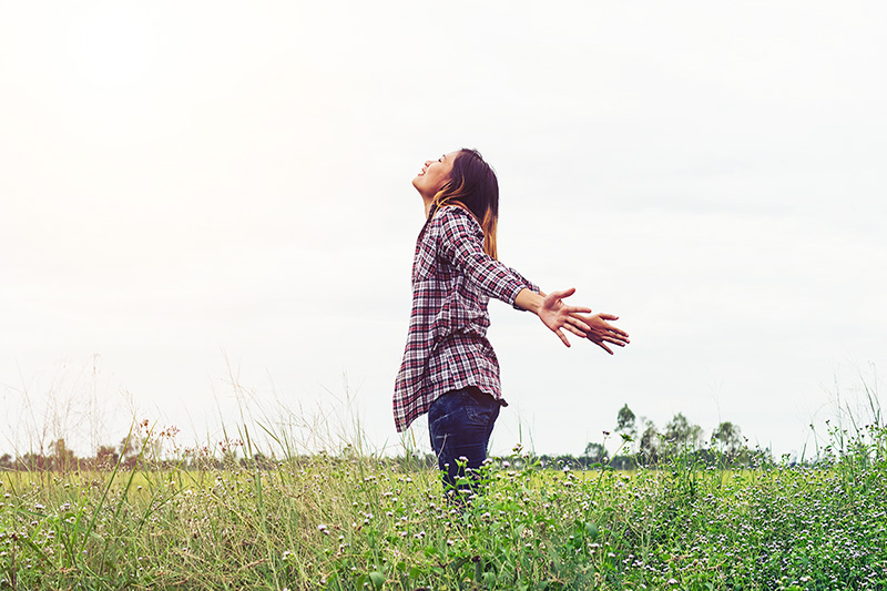 woman in a field, learning how to cope when stress and anxiety hits