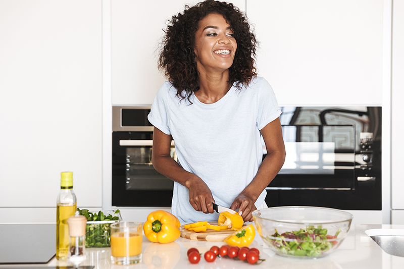 Woman cutting peppers, foods that are good for skin health