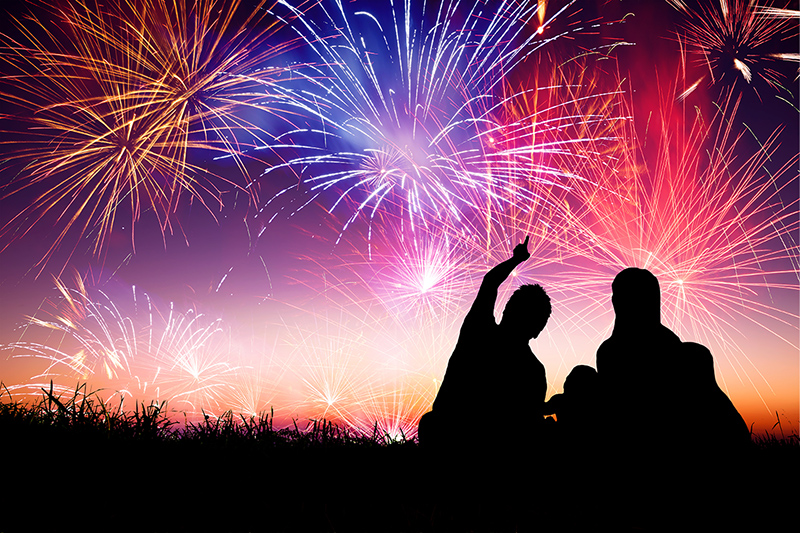 Family outside at night watching fireworks, staying safe while watching fireworks
