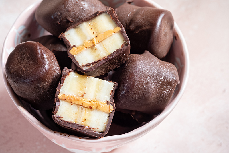 chocolate covered banana bites with peanut butter in a bowl, recipe
