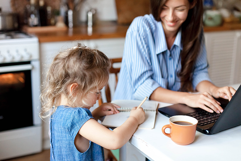 Mom working from home and daughter doing her schoolwork, how to balance work, school, life.