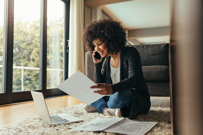 Woman looking at her computer while on the phone, what are some misconceptions about health insurance?  lg