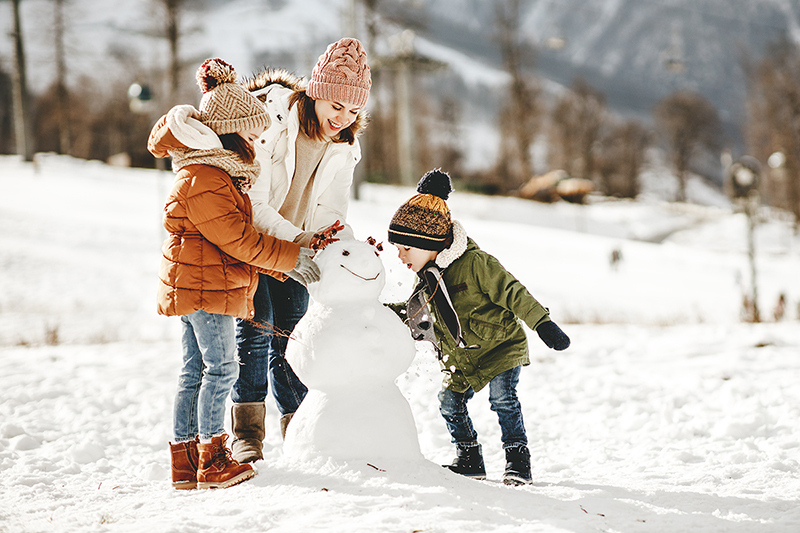 Mom with her children outside playing in the snow, how to stay motivated when it's dark outside