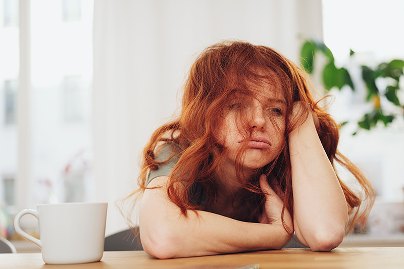 Woman feeling really tired in her kitchen, Natural energy boosters