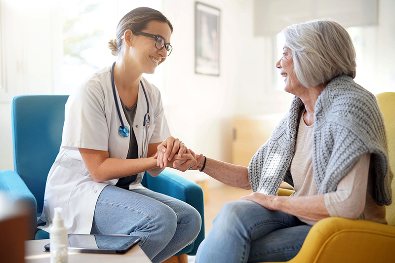 Female doctor holds the hand of older female patient, 5 benefits of medical home