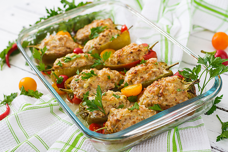 Sliced bell peppers filled with ground turkey in a pan. 
