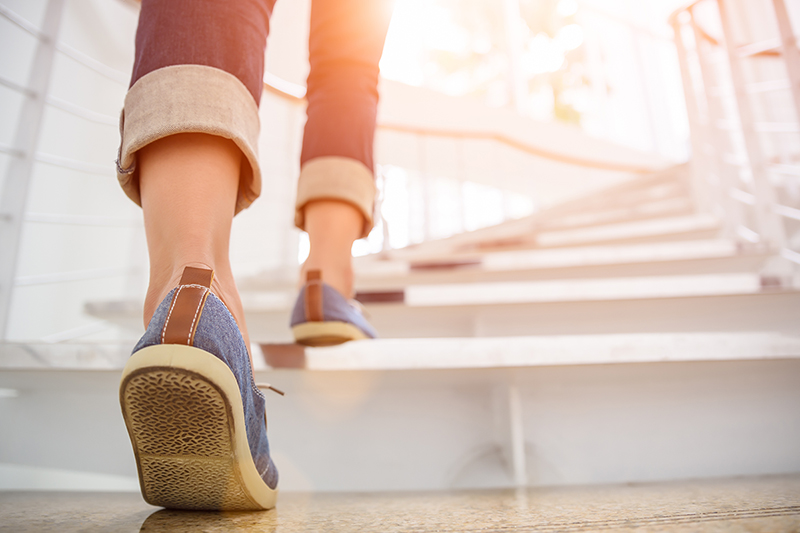 Woman walking up the stairs as a way to prevent chronic illnesses