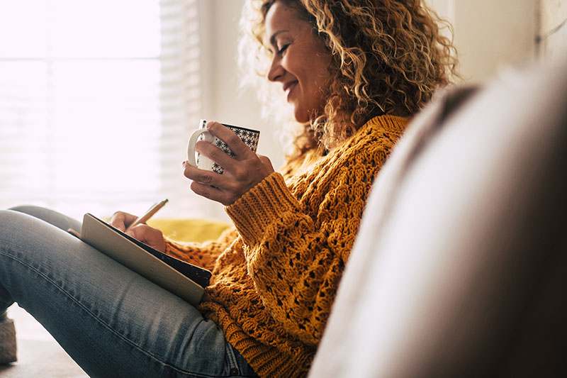 Lady at home writes to-do list to prepare for the week ahead.