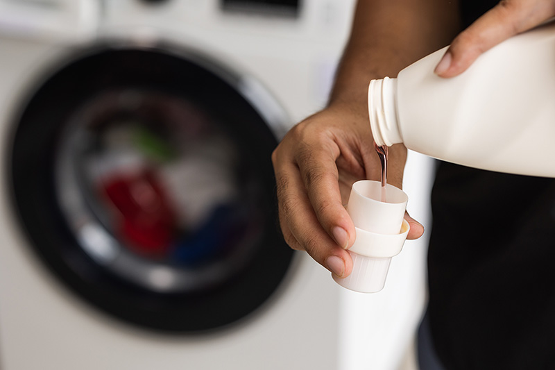 Man pours laundry detergent for washing clothes.