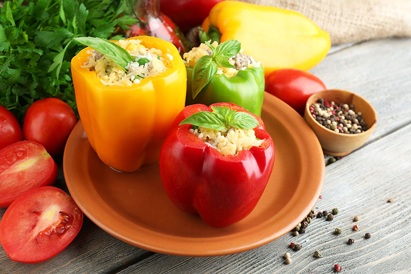 Three no-cook lemon garlic chicken salad stuffed peppers on a plate are ready to be served. 