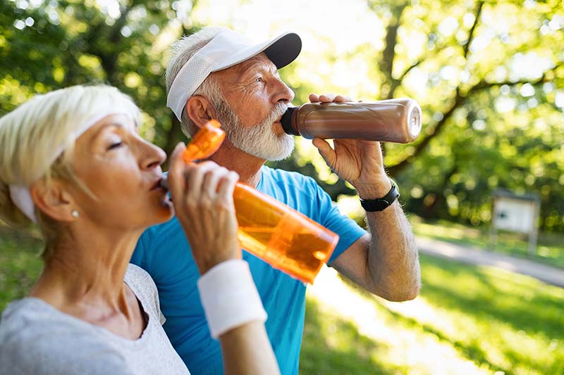 Senior couple staying hydrated and avoiding dehydration by drinking water.