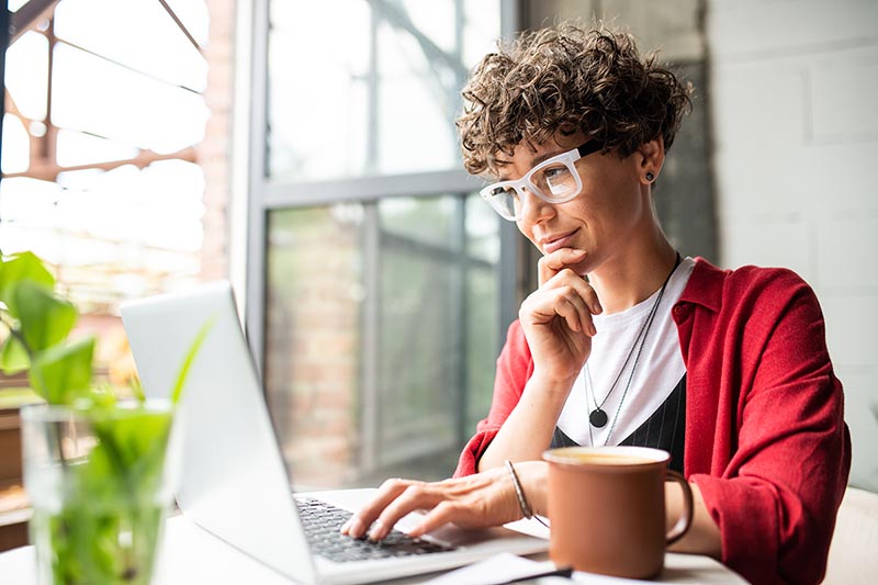 Middle aged female works on the computer to learn more about open enrollment and health plans.