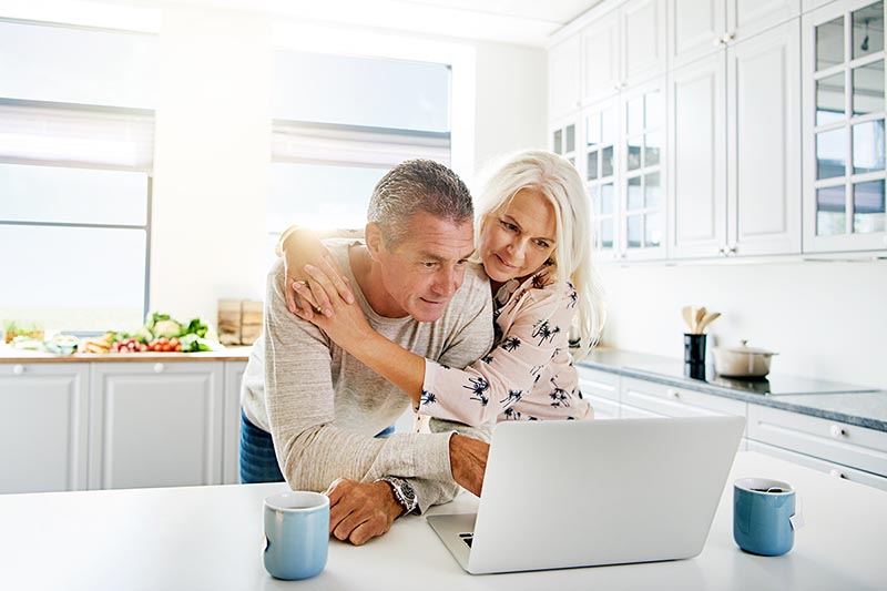 Happy older couple looks at Medicare Advantage plans together. 