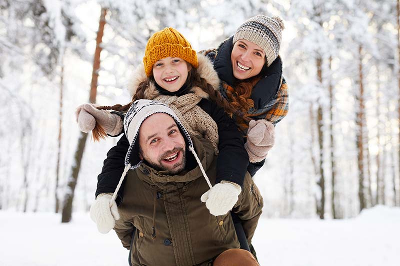Playful happy family with strong immune system in winter forest smiling