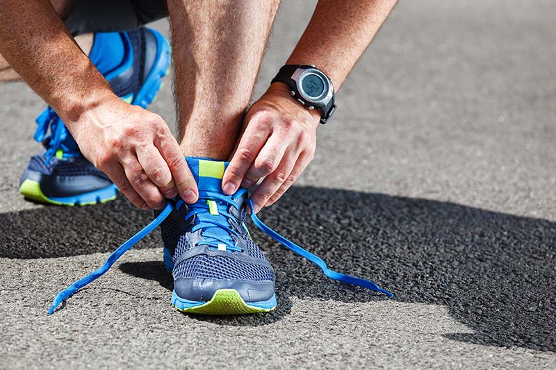 Runner fixing shoe to prevent blisters.
