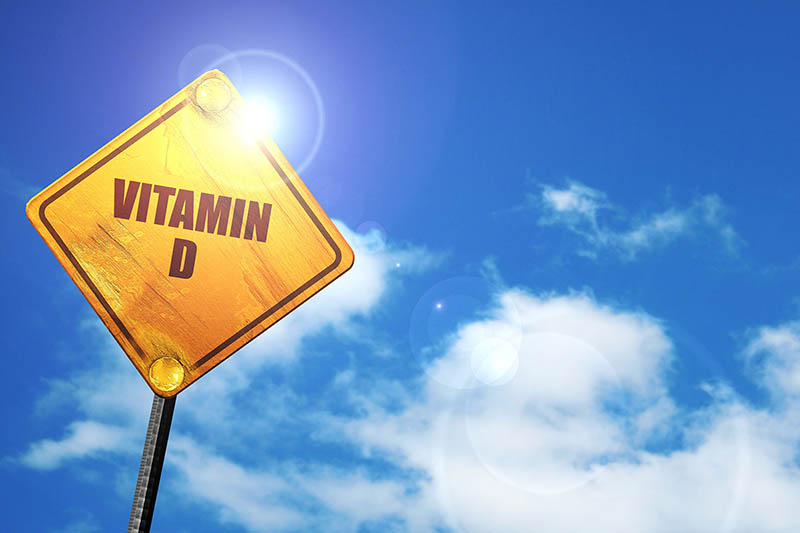A vitamin D traffic sign shades against the sun behind. 