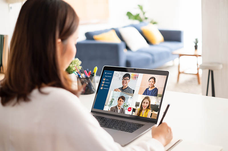 A woman works remotely and has a conference call with the team.