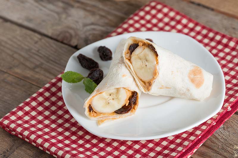 Banana rolled up in a tortilla with almond butter.