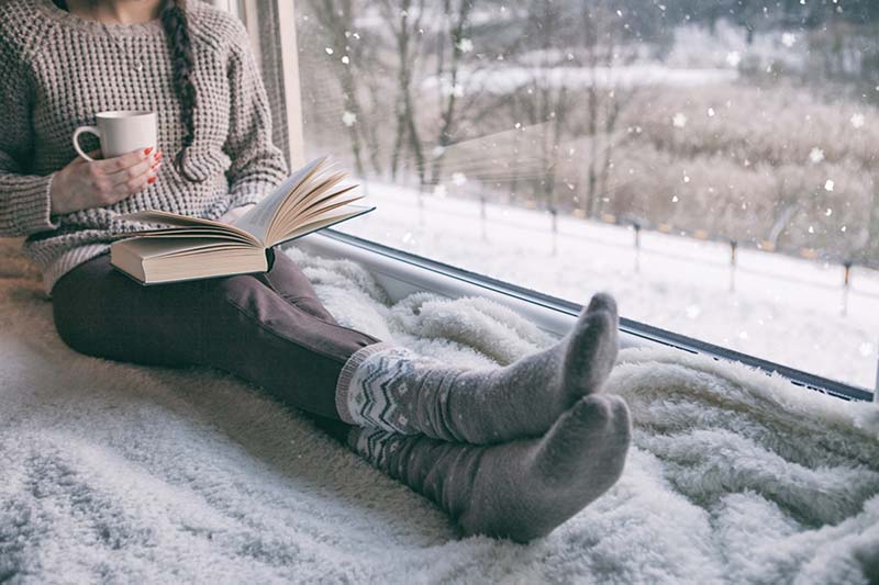 A woman sits inside to survive winter.