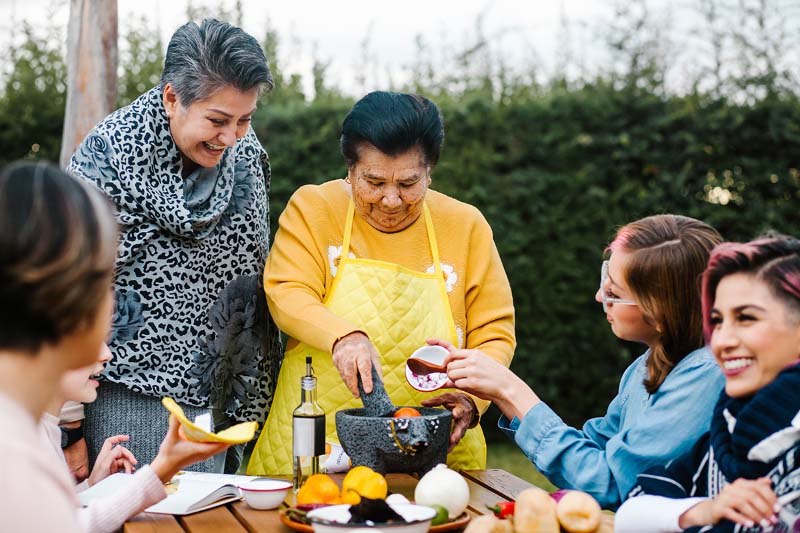 Familia mexicana comiendo comida junto con su abuela.
