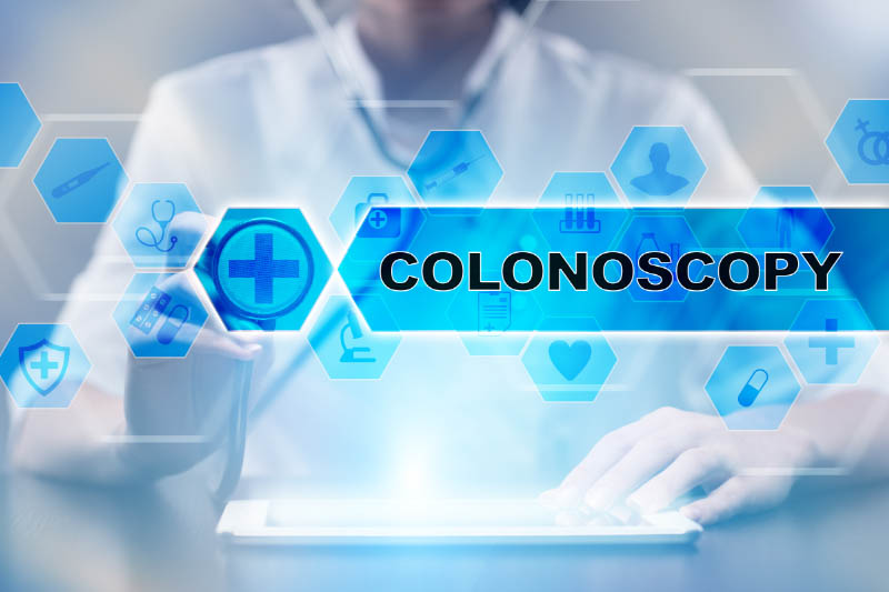 A doctor looks up colonoscopy information on a tablet.