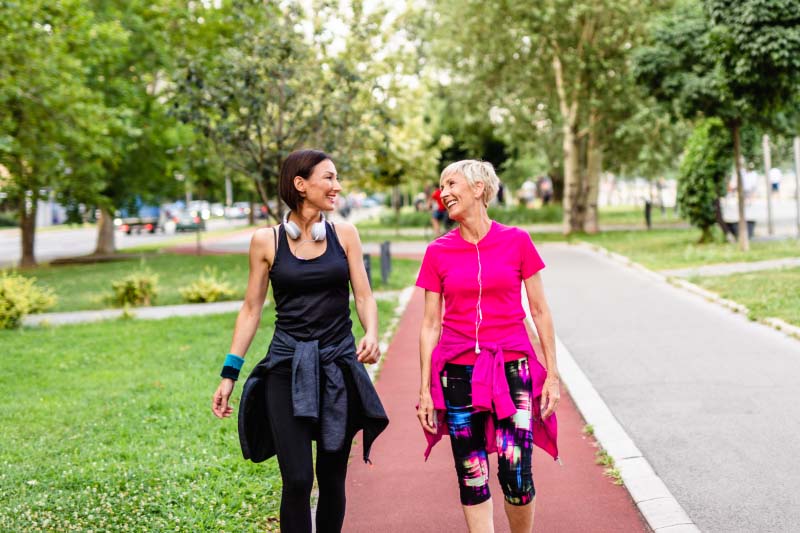 Mother and daughter exercise outdoors.