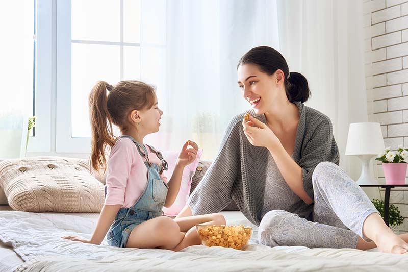 Mother and daughter snack on popcorn