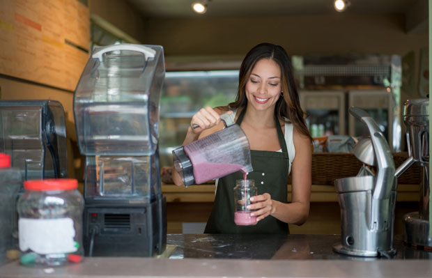 woman at smoothie shop pouring smoothie