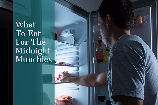 Man looking into a refrigerator reaching for a snack, midnight munchies