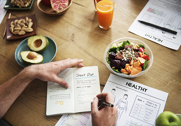 weight loss planning, man writing out plans in notebook