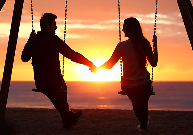 Man and woman holding hands on a swing set, learn how to strengthen relationships