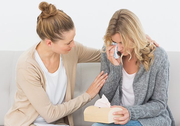 One woman crying while being comforted by her friend. There are many reasons why crying can be healthy. 