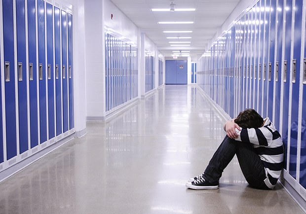 Boy in school hallway, how to help your children deal with bullying