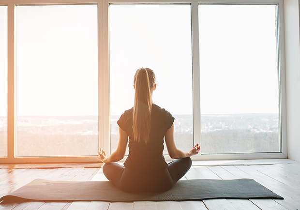 Benefits of yoga, girl doing yoga in front of a window
