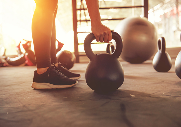 Woman lifting kettleball, reasons to love strength training