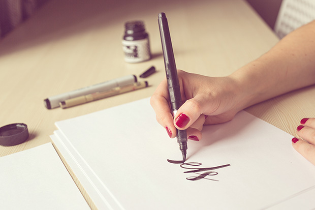 Woman writing in calligraphy on a piece of paper