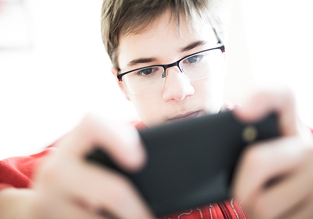 Child looking at phone, how to cut down on screen time 