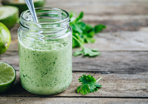 Jar of cilantro ranch dressing, with limes and cilantro