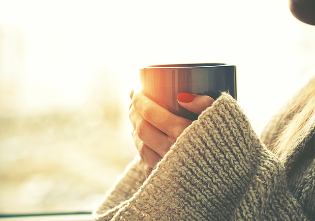 Woman holding a cup of coffee, coffee benefits