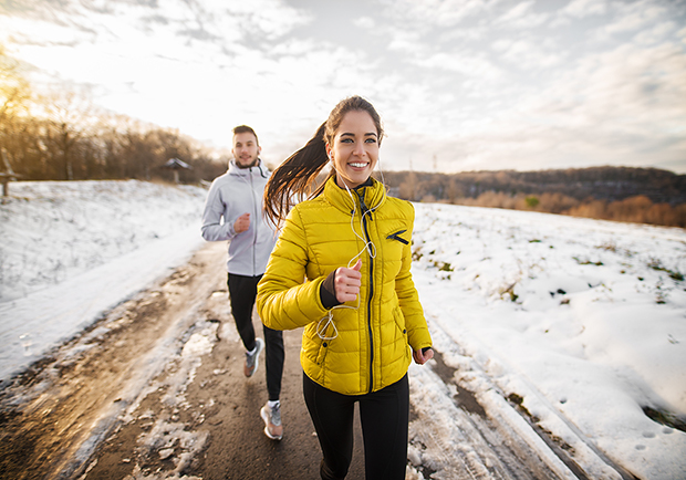 Woman and man running outside, tips for staying fit during the cold months
