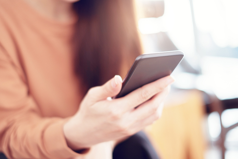 Woman hand holding a mobile phone, She is using the Select Health Mobile App to view her ID Card