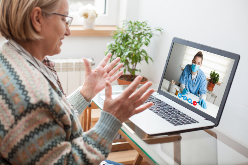 Woman using laptop for virtual doctor visit.