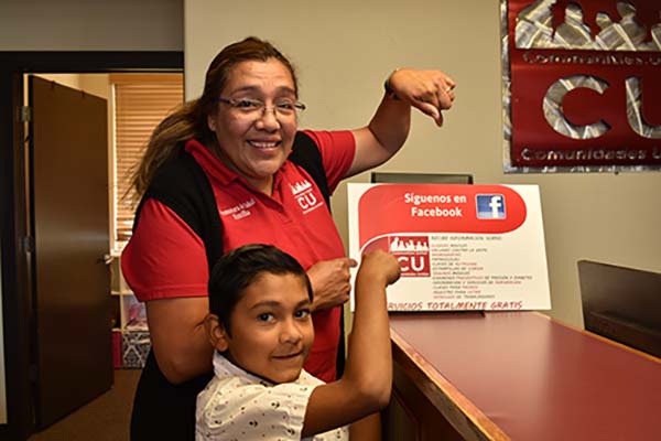  woman and boy pointing to facebook sign