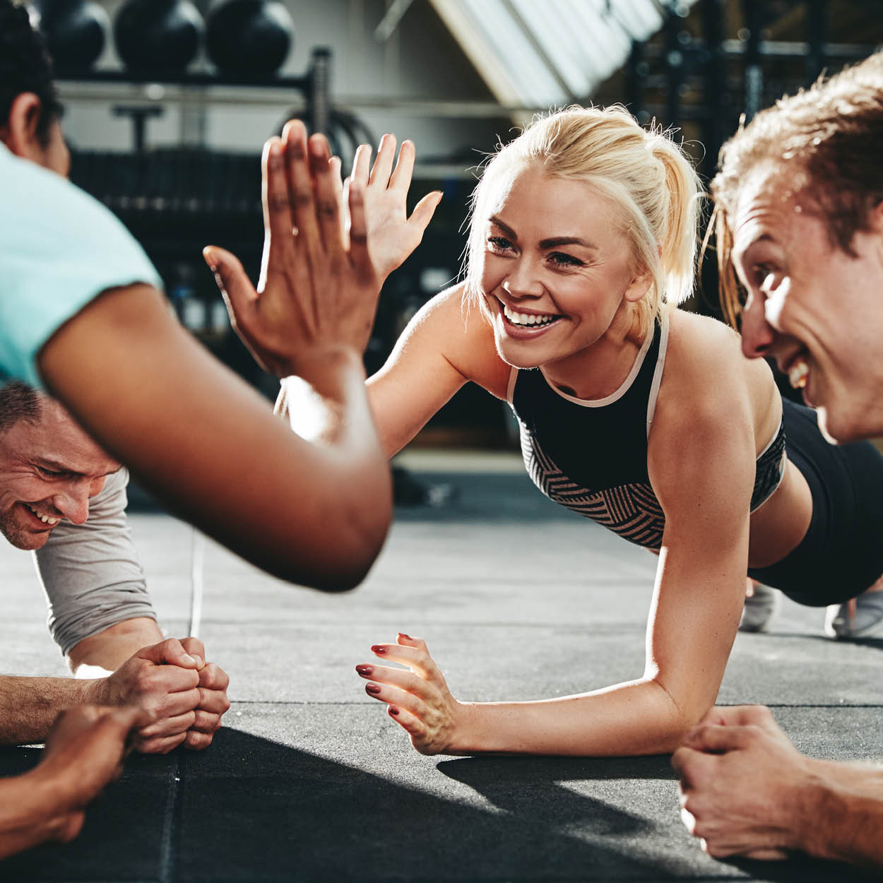 woman and men exercising, health coaching,  happy about accomplishment and giving high five