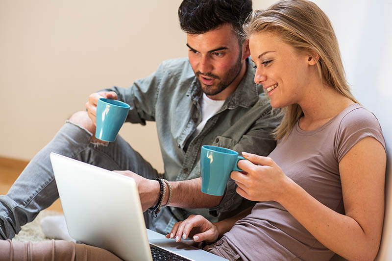 Couple sitting together reviewing health plan online.