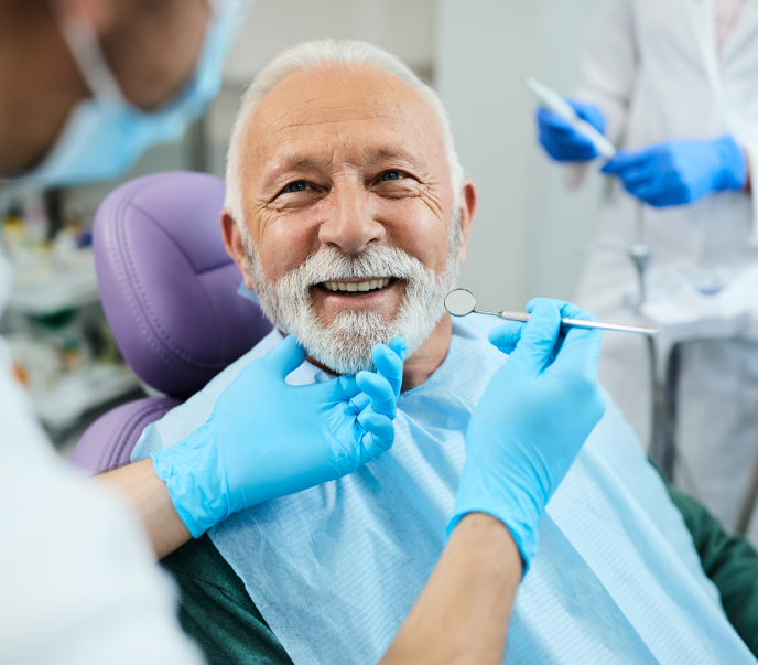 Man at a dentist office smiling and in conversation with dentists